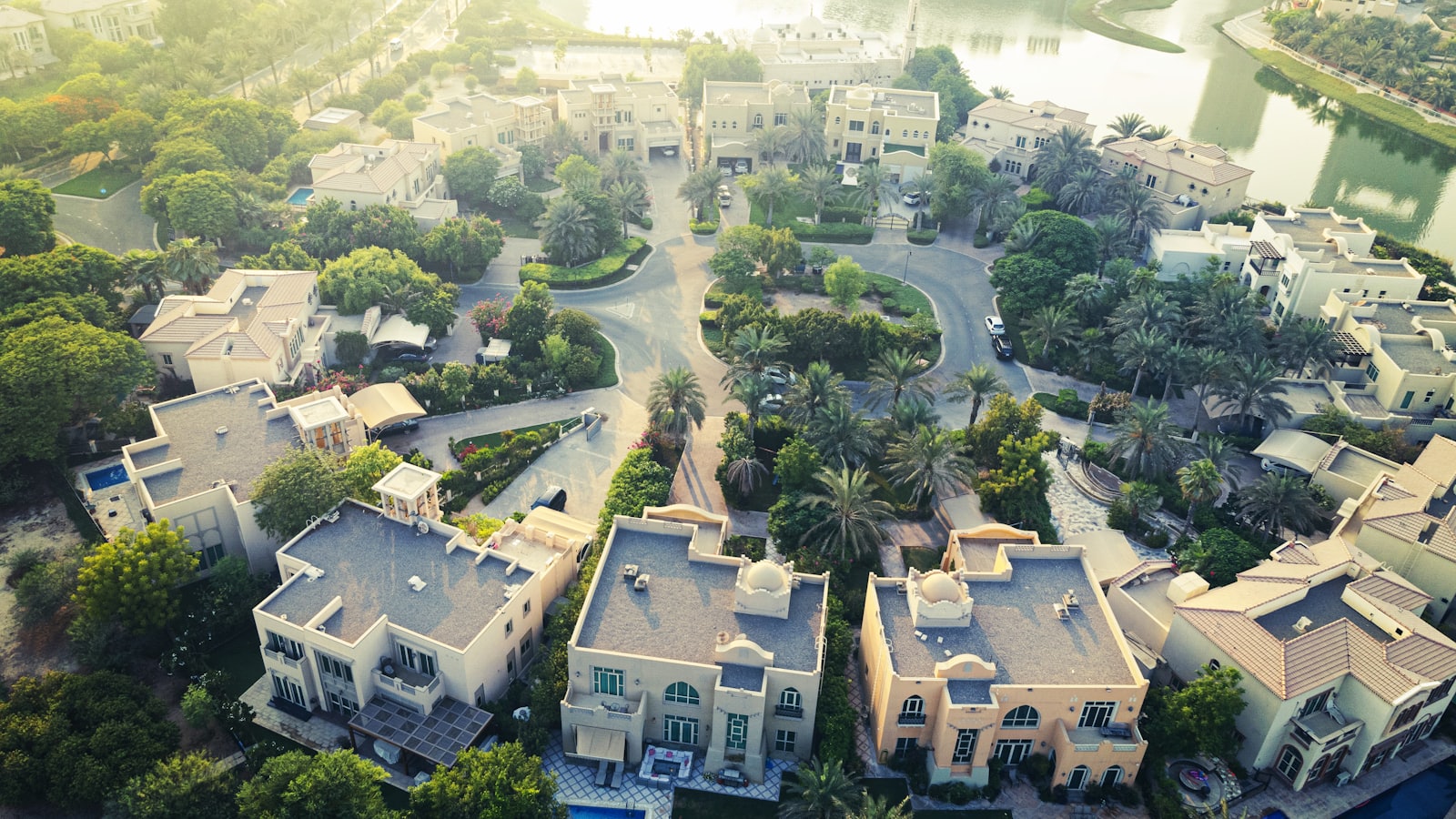 Aerial view of villas set among greenery and water in a Dubai golf community
