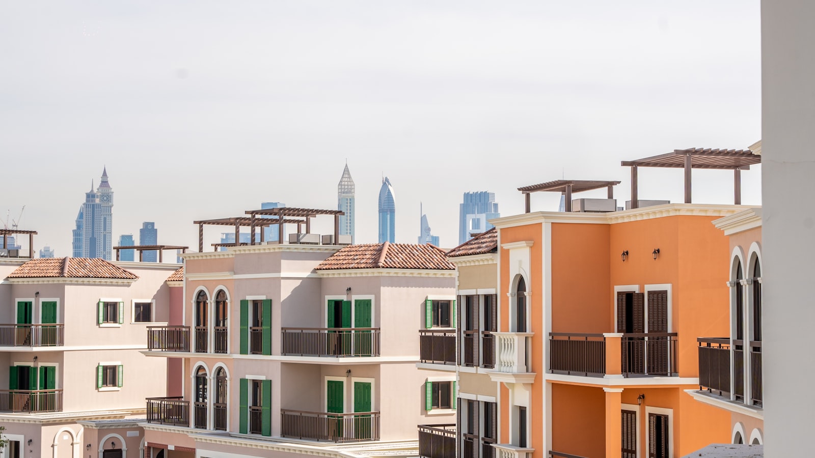 Low-rise Mediterranean-style residential buildings in Dubai with the city skyline behind